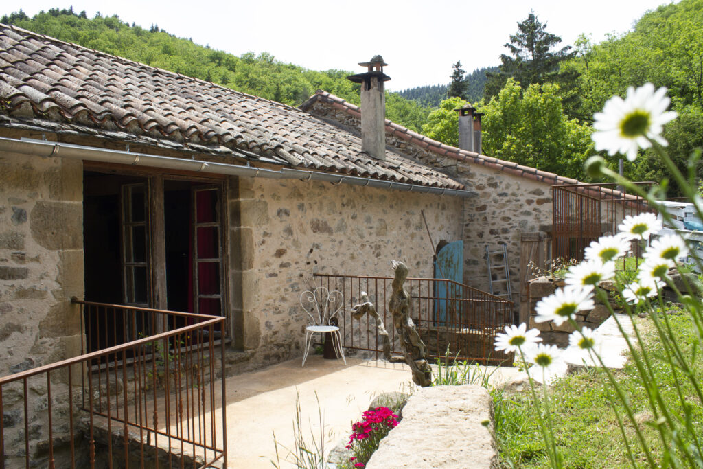 Une vue de la terrasse fleurie sur l'auberge de Lascours à Ceilhes et Rocozels